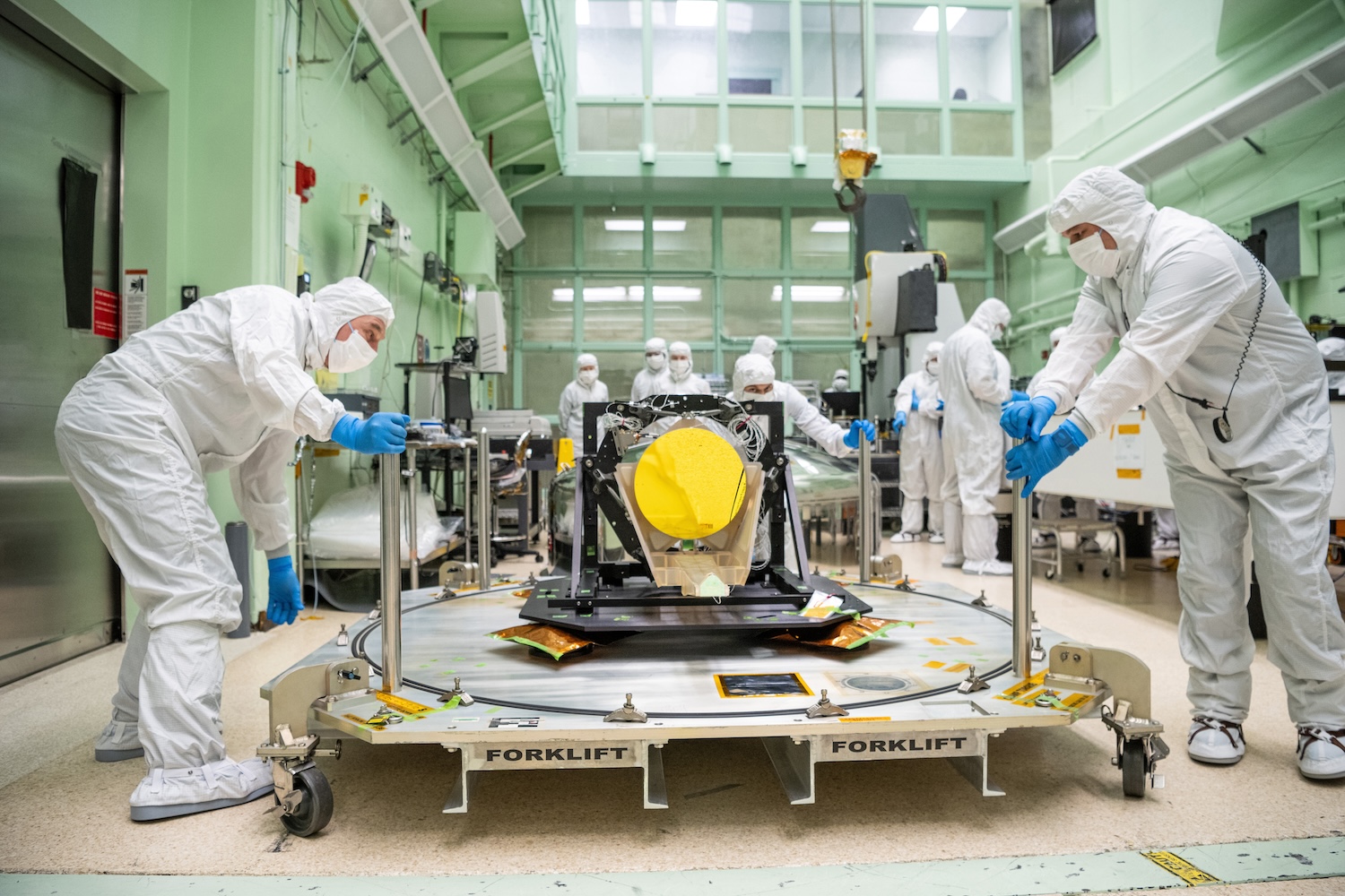 Clean room technicians move a prototype LISA telescope. Credit: NASA / Dennis Henry