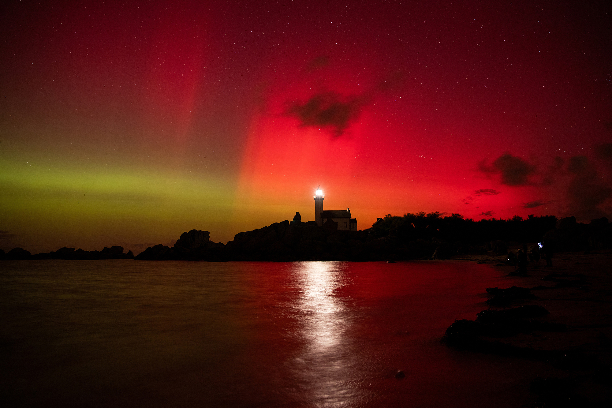 On October 10, 2024, the aurora borealis turns red and green over the Ponteval lighthouse in Brignogan, North Finistère, France. (Photo by Vincent Feuray / Hans Lucas / Hans Lucas via AFP) (Photo by VINCENT FEURAY/Hans Lucas/AFP) via Getty Images)