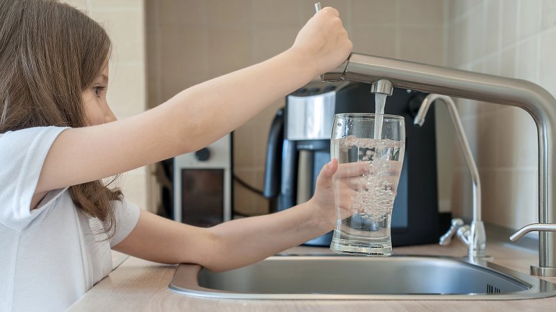 girl getting water from faucet