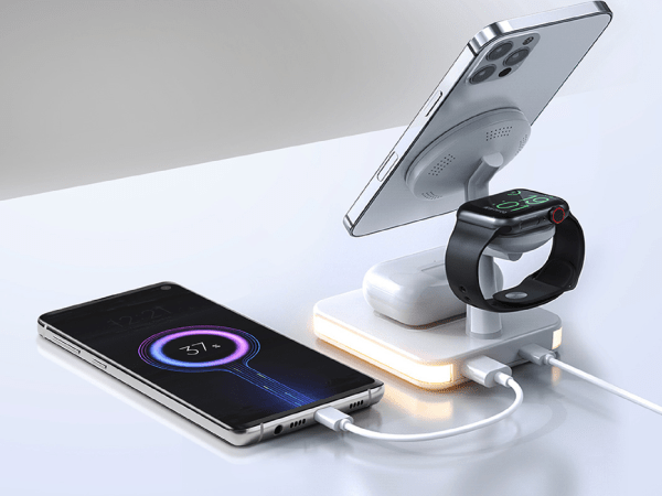 A bedside charging station and lamp on a white desk.