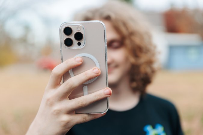 A person holding their smartphone in front of their face to take a selfie