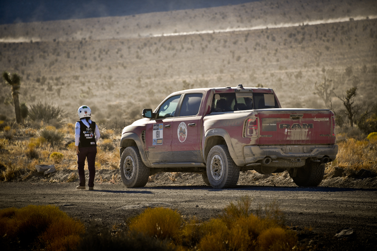 a person walking next to a red pickup truck