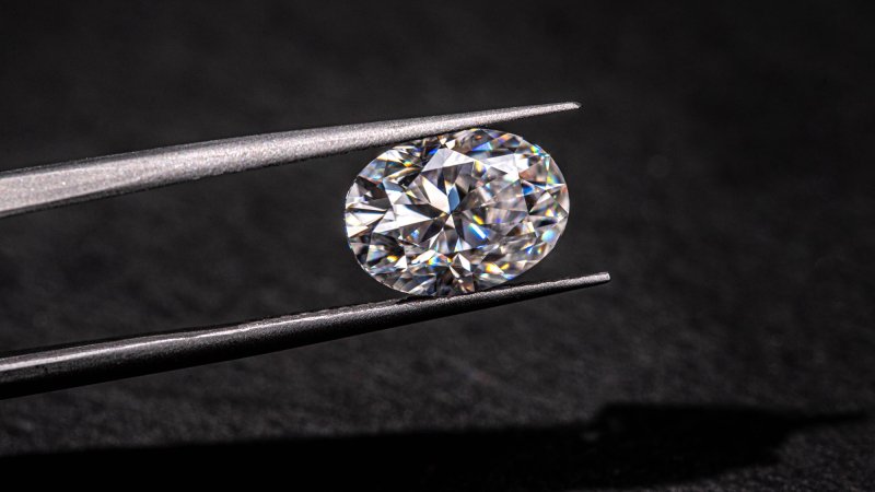 Close up of tweezers holding small diamond