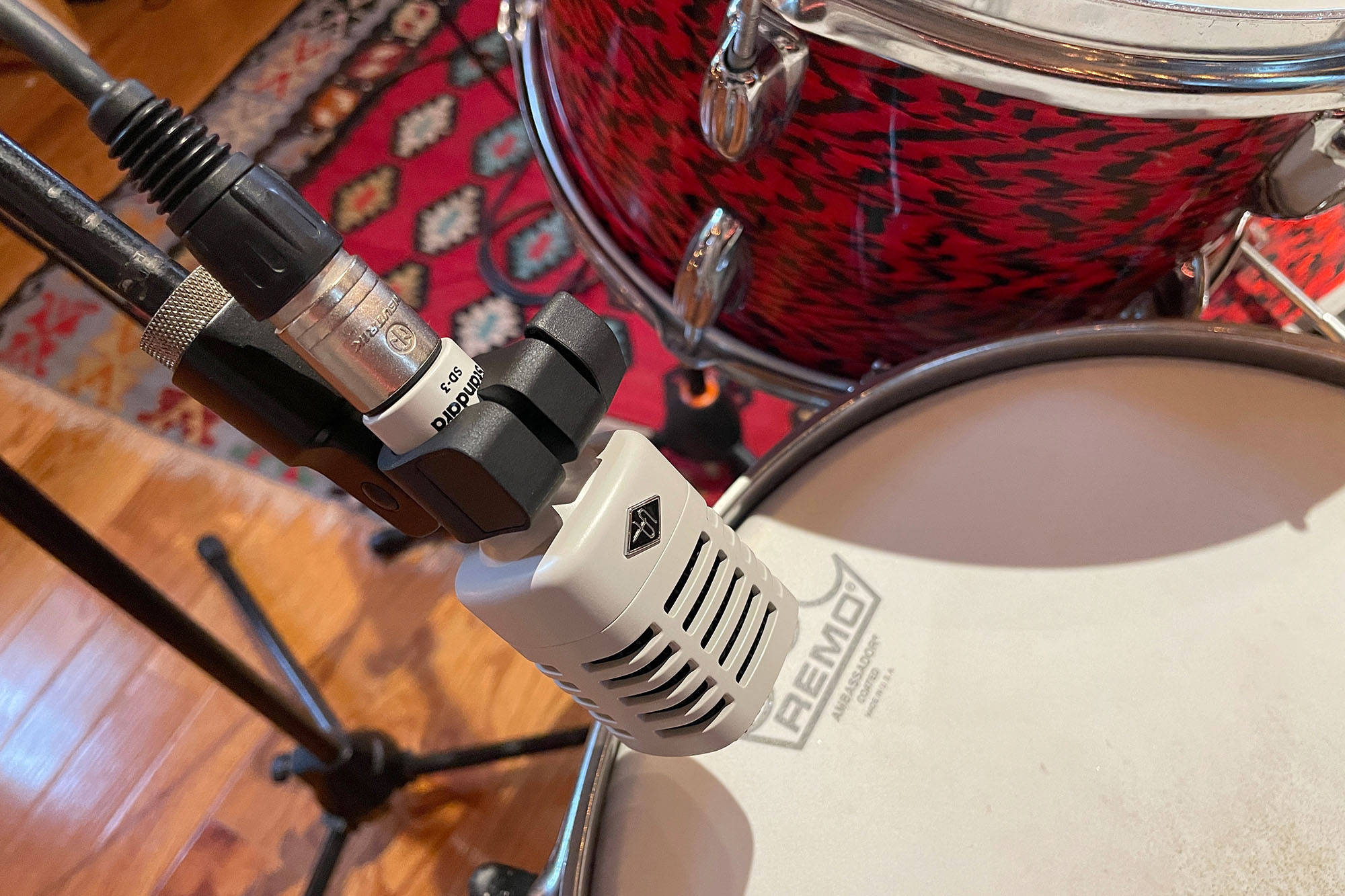 A Universal Audio SD-3 drum mic on a stand above a snare