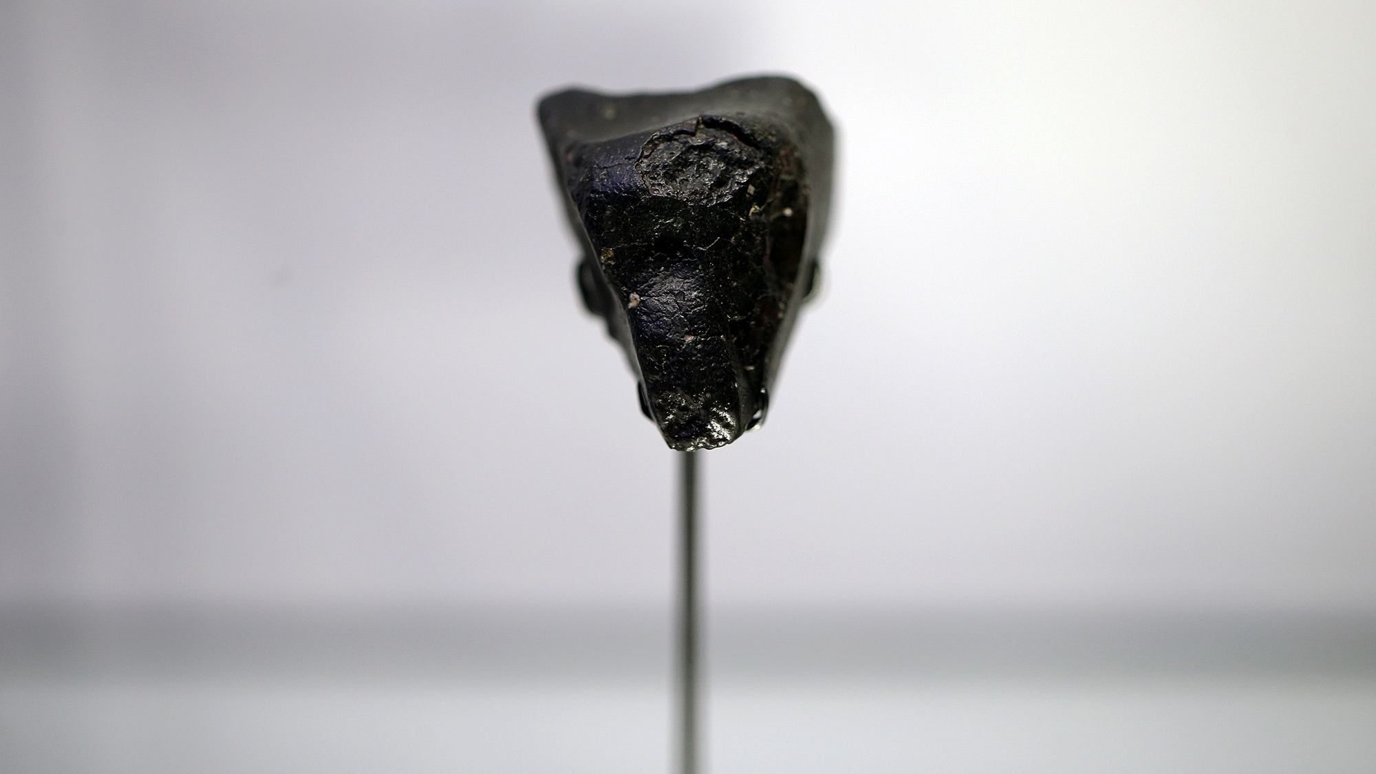 a black meteorite on display at a musuem