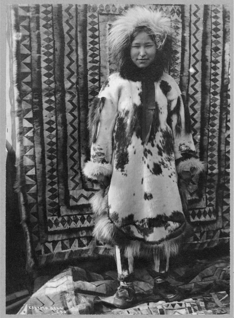 a photograph from the 1900s of an inuit girl wearing various furs and pelts for cold weather