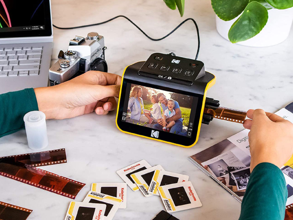 A person digitizing slides on a desk using a Kodak Slide n Scan.