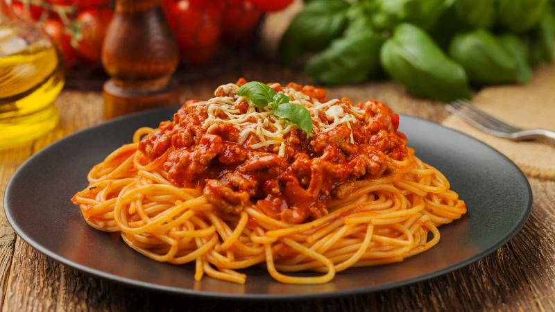 a plate of spaghetti with red sauce on top