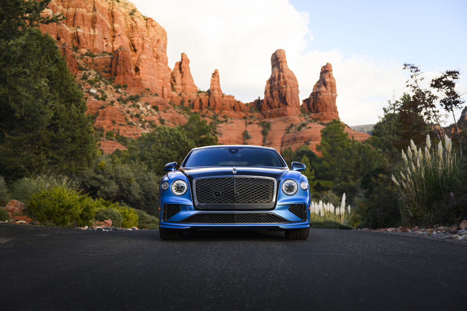 a blue luxury car in front of desert scene