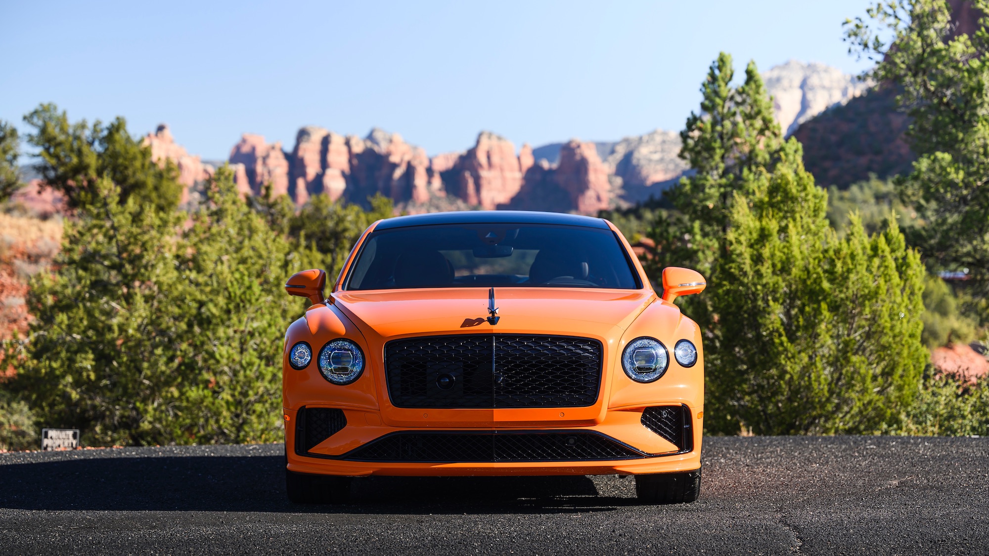 an orange luxury car faces the camera