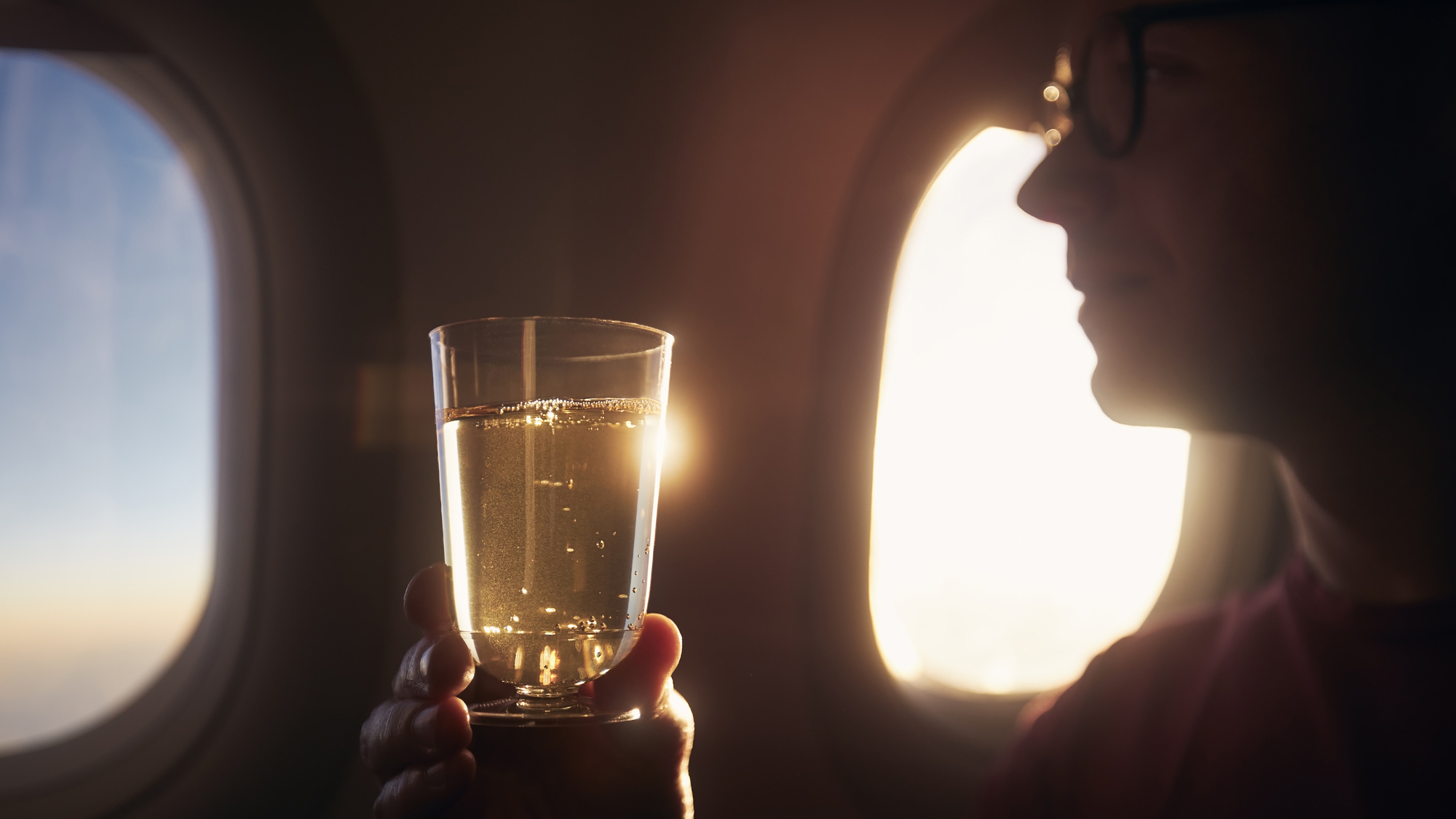 person drinking ginger ale on a plane