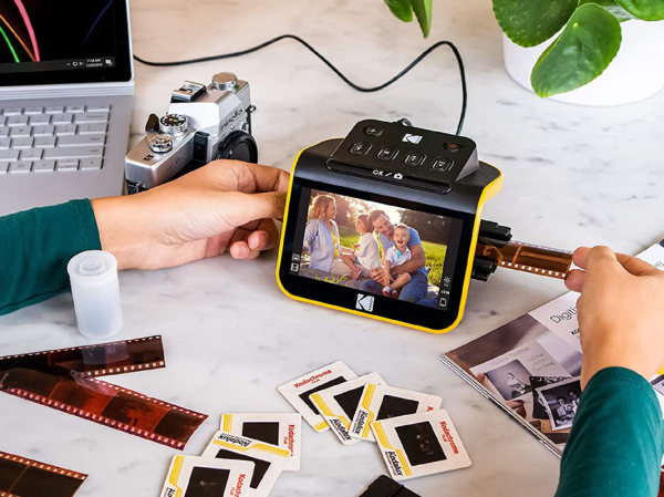 A person sliding film on the Kodak Slide n Scan.