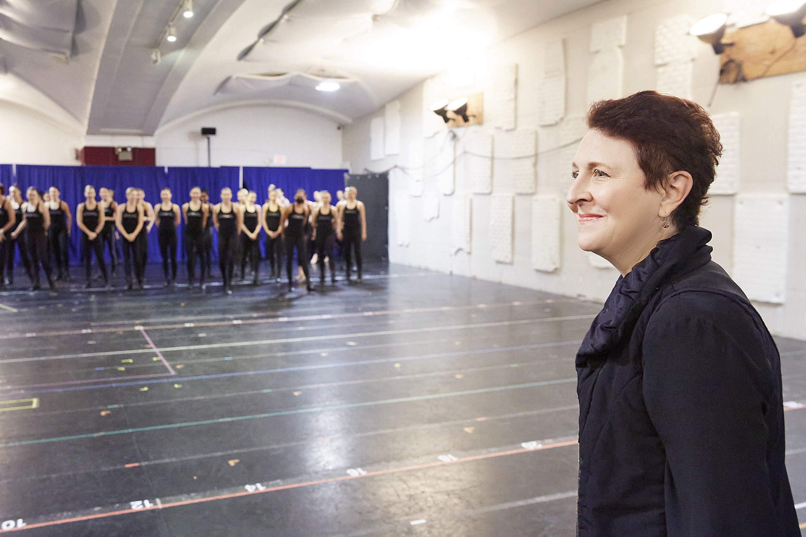 a woman stands in a rehearsal studio with the rockettes