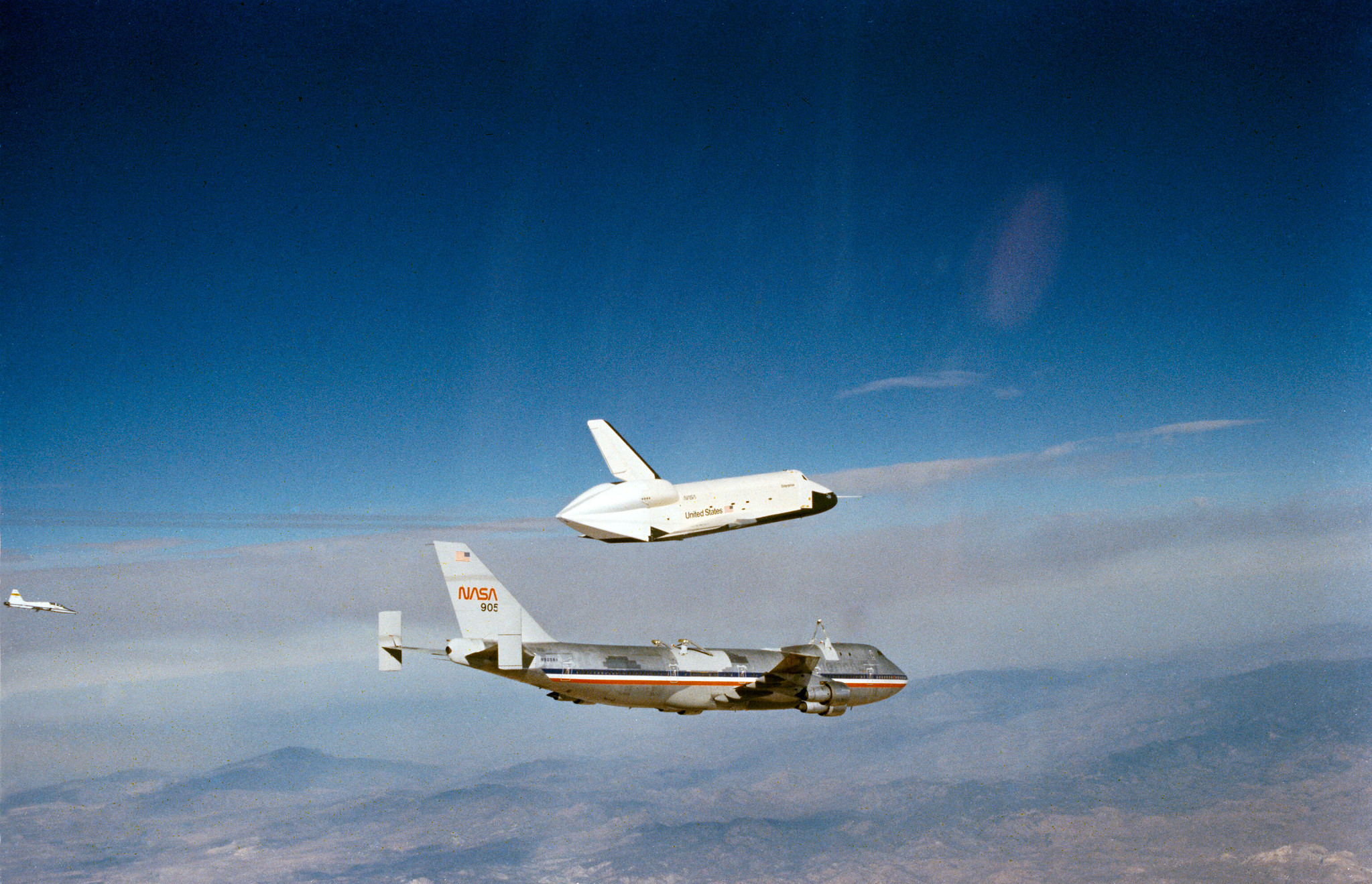 space shuttle flying above airplane