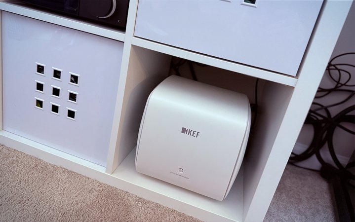  A white KEF KC62 powered subwoofer in a white IKEA cubby