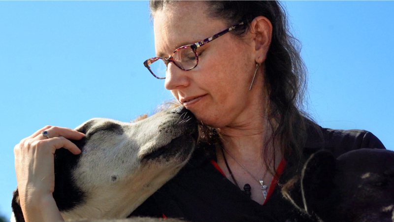 a woman nuzzles a dog