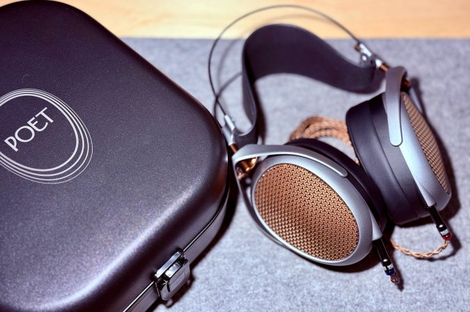 The Meze Audio POET headphones and case shown on a grey felt deskpad