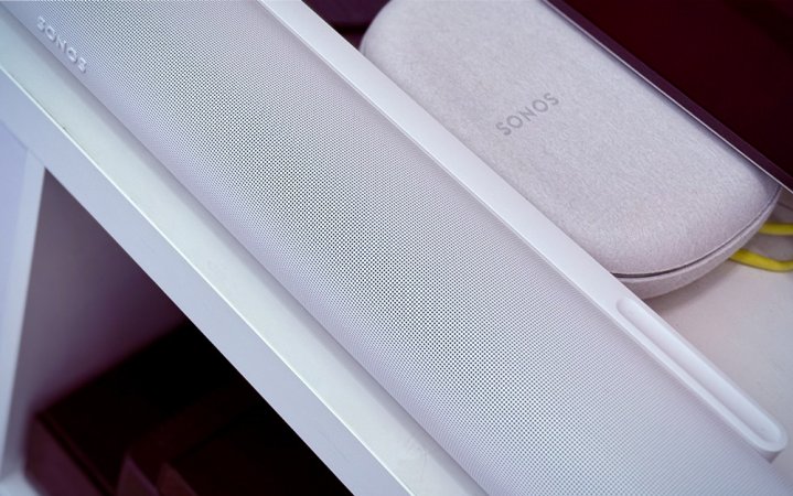  Close up of white Sonos Arc Ultra Dolby Atmos soundbar on a white credenza with the Sonos Ace headphones case behind it