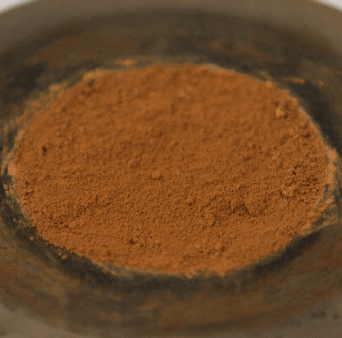 A disc of orange-terracotta colored dust fills the frame. The dust looks quite soft and fine, more like flour than sand