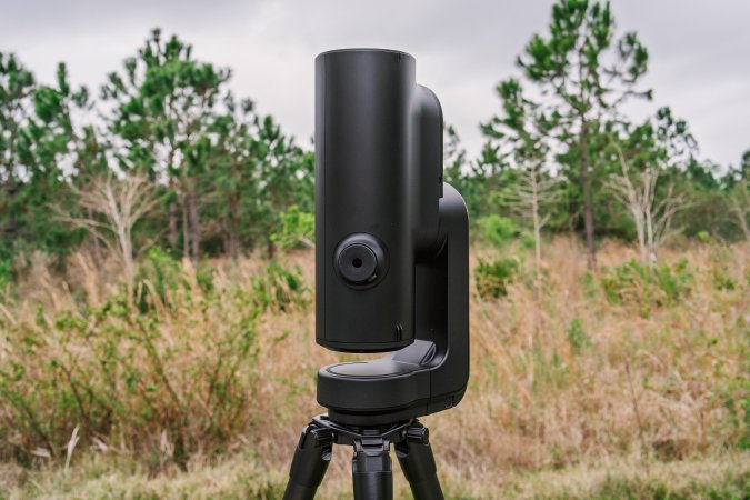  A black Unistellar Odyssey Pro smart telescope pointing straight up on a tripod in a field in Florida