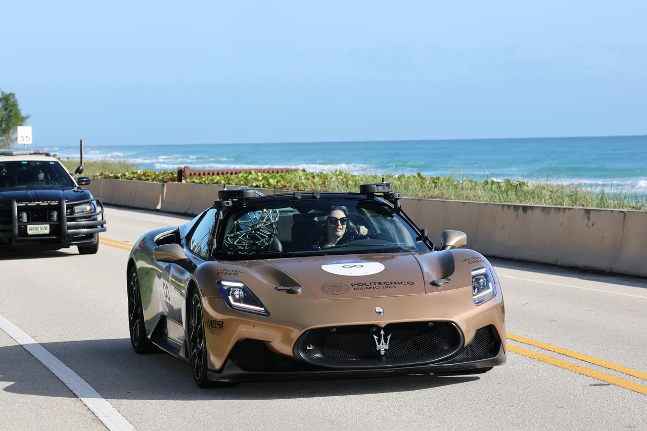 a sports car on a highway near the ocean