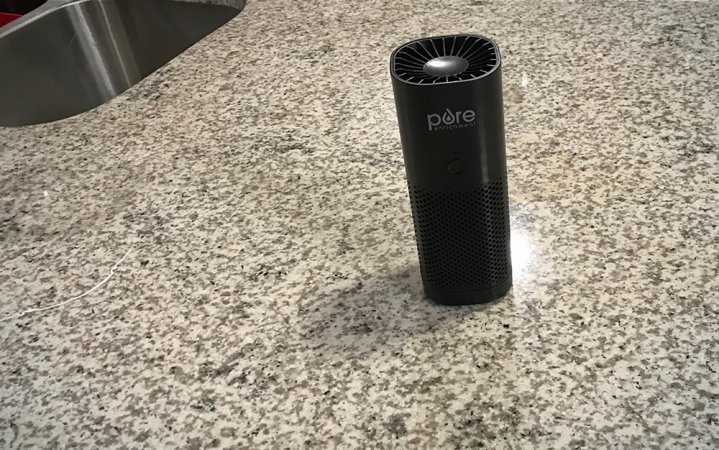  Cylindrical black Pure Enrichment portable air purifier sitting on a kitchen counter